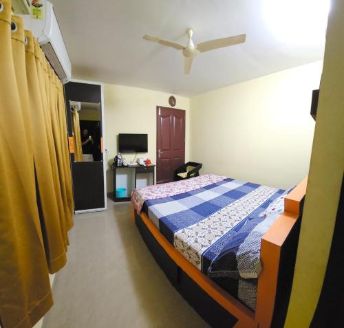a bedroom with a bed in a room with yellow curtains at Joys Stay in Trichūr