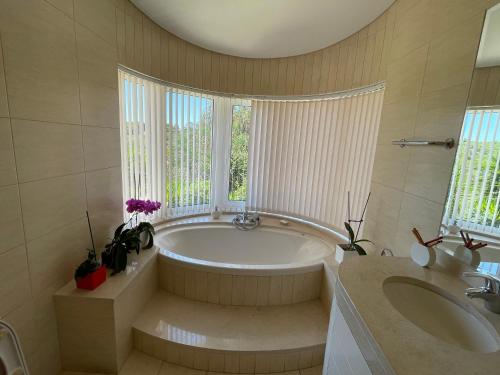a large bathroom with a tub and a sink at GARBE - Private Villa,Total Privacy, Infinity Swimming Pool, Close to Beaches in Porches