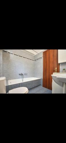 a bathroom with a tub and a toilet and a sink at Cozy apartment next to the port! in Piraeus