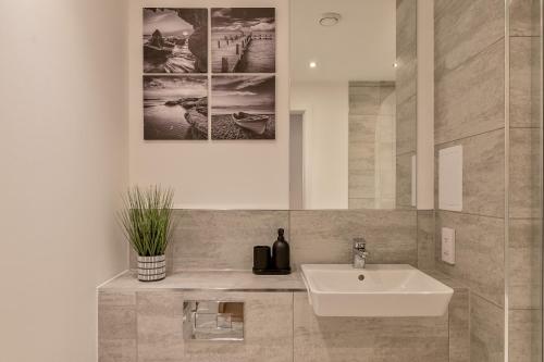 盧頓的住宿－Luxury Apartment-Free Parking-Central Location，一间带水槽和镜子的浴室