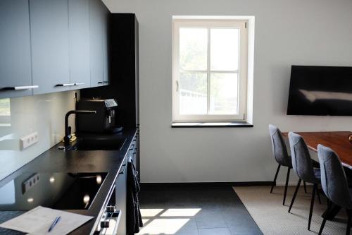 a kitchen with a sink and a table and a window at Trautesheim Ferienwohnungen in Wangen im Allgäu