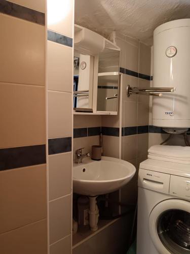 a small bathroom with a sink and a washing machine at Lamar in Cres