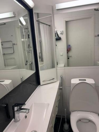 a bathroom with a toilet and a sink and a mirror at BlueSolarPearl R - Vaihtoehto majoittumiselle in Nokia