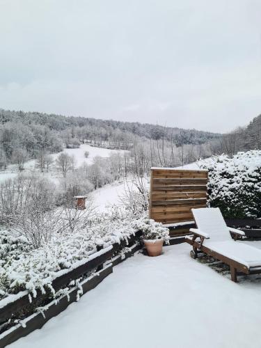 a snow covered patio with a bench and a table at Chalet Spessart in Dammbach