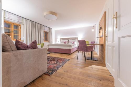 sala de estar con sofá y cama en Modernes Apartment in altem Bauernhaus en Aflenz Kurort