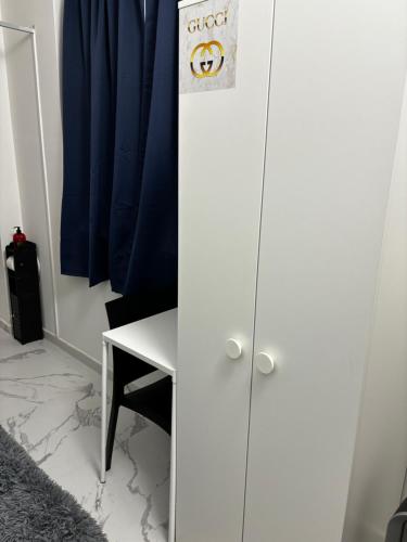 a white cabinet with a sign on it next to a desk at Villa Life in San Donato Milanese