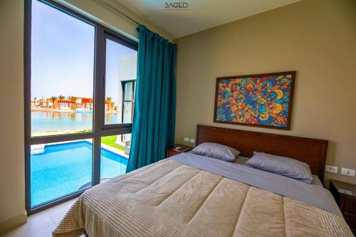 a bedroom with a bed and a view of a pool at Best and cheapest villa in town in Hurghada