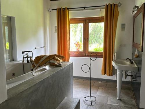 y baño con bañera y lavamanos. en Nidahasa Heritage Villa Wadduwa, en Wadduwa