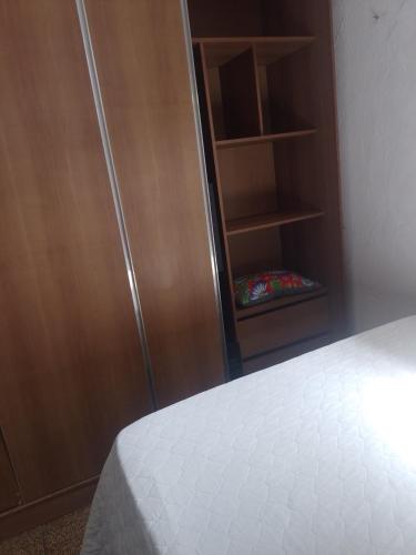 1 dormitorio con 1 cama y armario de madera en Casa Completa en Olinda