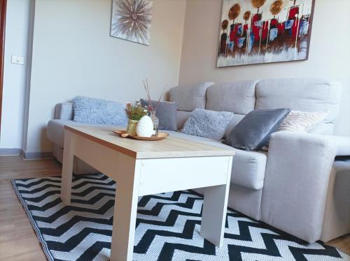 a living room with a table and a couch at Apartamento Sobreira en centro Allariz con WIFI in Allariz