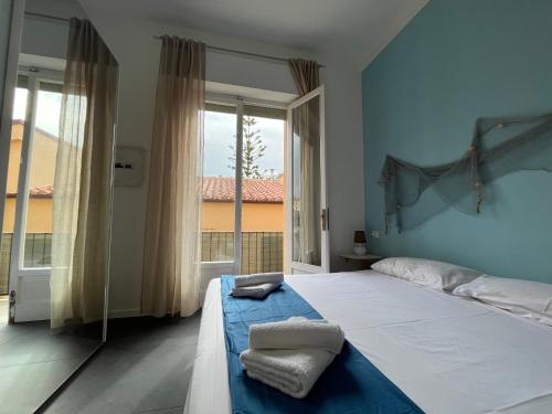 une chambre avec un grand lit et une grande fenêtre dans l'établissement La Terrasse - Appartamento L'Orso, Terazzo vista mare, à La Maddalena