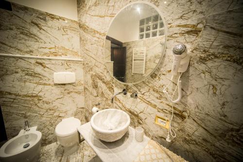 La salle de bains est pourvue d'un lavabo et d'un miroir. dans l'établissement Borgo Boutique Home, à Nettuno