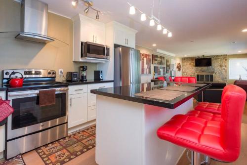 una cocina con encimera y sillas rojas. en C19 Conscious, QUIET, ADULT Lake View Rental, en Sammamish