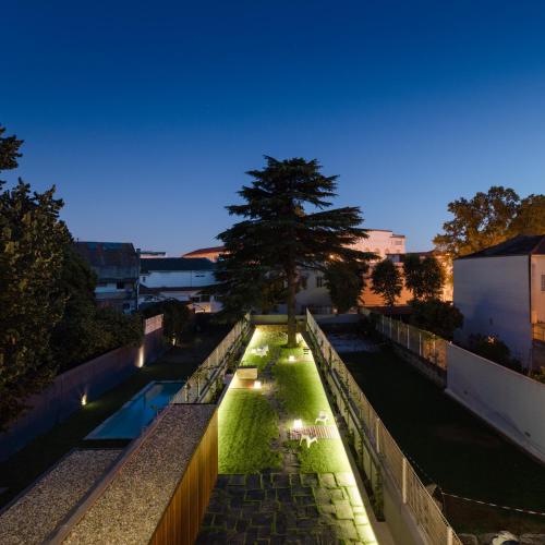 a garden with a tree on the side of a building at Baumhaus Serviced Living - Art & Design Apartments in Porto