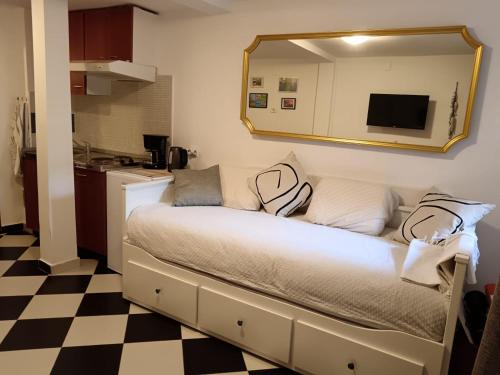 a bedroom with a bed with a mirror and a checkered floor at Lamar in Cres