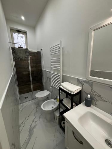 Baño blanco con lavabo y aseo en Villa Life, en San Donato Milanese