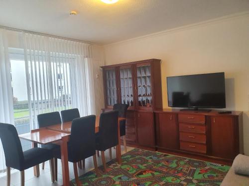 ein Esszimmer mit einem Tisch und einem Flachbildfernseher in der Unterkunft Ferienwohnung/Montagewohnung 2 in Bad Driburg