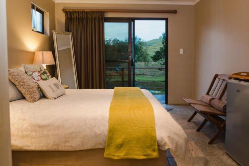 a bedroom with a large bed and a balcony at Hakuna Matata Game Farm in Great Brak River