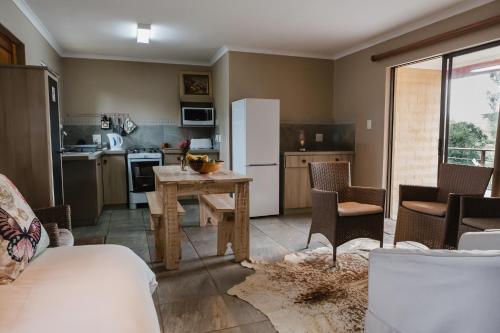 a kitchen with a table and chairs and a refrigerator at Hakuna Matata Game Farm in Great Brak River