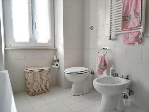 bagno bianco con servizi igienici e lavandino di La Casina di Enea a Cascia