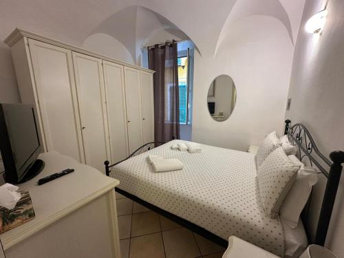 ein kleines Schlafzimmer mit einem Bett und einem Spiegel in der Unterkunft [2 passi dal mare di Alassio] Ampio trilocale in Alassio