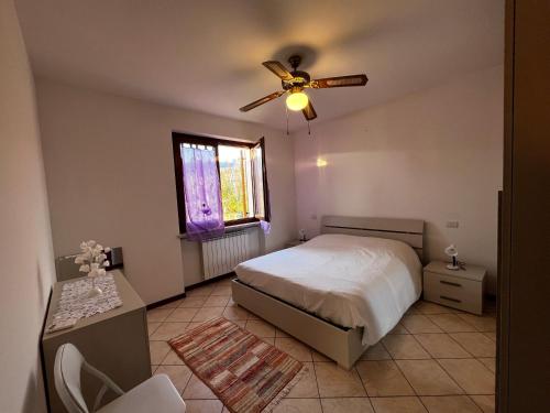 a bedroom with a bed and a ceiling fan at "IL VIGNETO" Apartment in Negrar