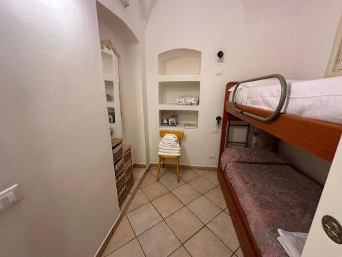 a small room with a bunk bed and a chair at [2 passi dal mare di Alassio] Ampio trilocale in Alassio