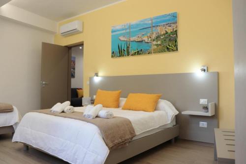 una camera da letto con un grande letto bianco con cuscini arancioni di Casa Lu Mari a Sciacca