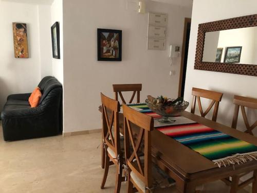 a dining room with a table and a couch at Apartamento El Eden in Playa de Gandia