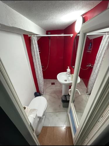 uma pequena casa de banho com WC e lavatório em London.Apartments em Pristina