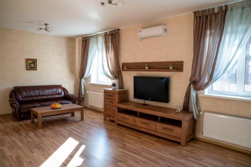 een woonkamer met een bank en een flatscreen-tv bij Guest house Kiev forest in Kiev