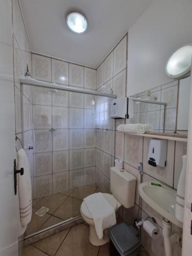 a bathroom with a toilet and a sink at Pousada Inn Engenho do Sonho in Rio das Ostras