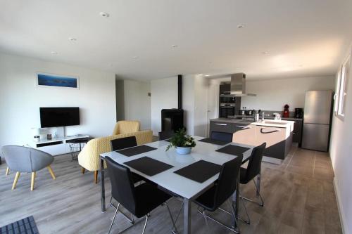 une cuisine et une salle à manger avec une table et des chaises dans l'établissement Gîte de l'Estuaire classé 3 étoiles, à Lézardrieux