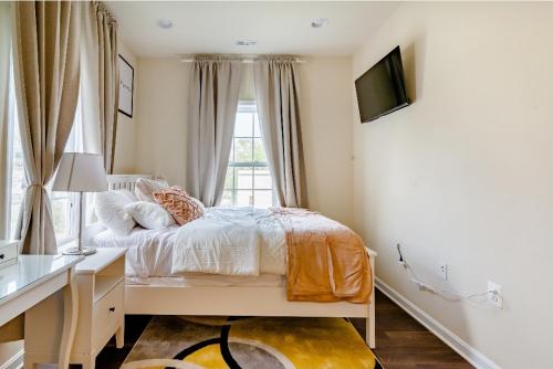 a bedroom with a bed and a desk and a window at Luxurious and Cheerful Room in Washington DC in Washington