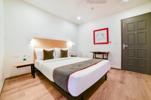 a bedroom with a large bed and a door at Townhouse Sarjapur Near Bellandur in Bengaluru