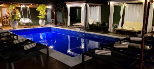 a swimming pool in a house with blue water at Hiu Hotel in Juquei