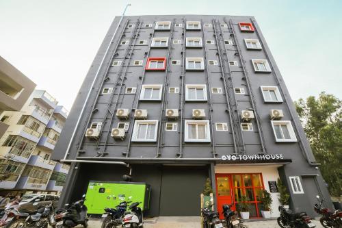 a tall gray building with motorcycles parked in front of it at Townhouse Sarjapur Near Bellandur in Bangalore