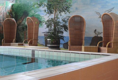 a swimming pool with two large swimming tubs in it at Hotel Restaurant Piccard in Vlissingen