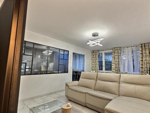 a living room with a couch and some windows at RESIDENCE SERENA in Torcy