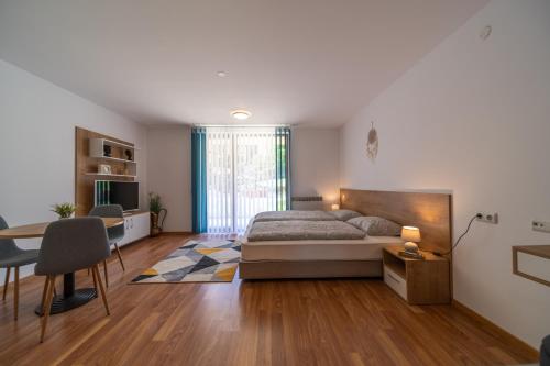een slaapkamer met een bed, een bureau en een tafel bij Pirin Sense Apartment Complex in Bansko