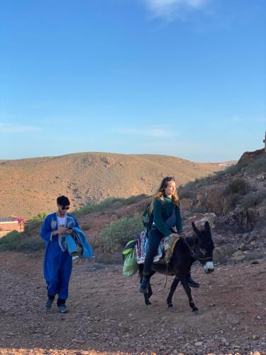 a woman riding on a donkey with a man at La casa wadie 3 in Sidi Ifni