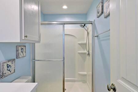 a bathroom with a shower with a glass door at Mary Lou's Hideout (11th St Bungalows #19) in Port Aransas