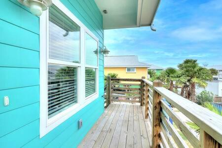 a blue house with a balcony with a window at Mary Lou's Hideout (11th St Bungalows #19) in Port Aransas
