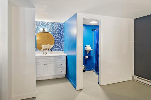a blue bathroom with a sink and a mirror at The Brooks Motel in Hillsdale