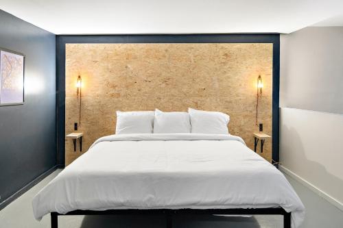 a bedroom with a large white bed with two side tables at The Brooks Motel in Hillsdale