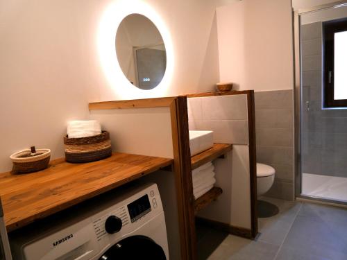a bathroom with a washing machine and a mirror at La ferme d'Hauteluce - Chalets in Hauteluce