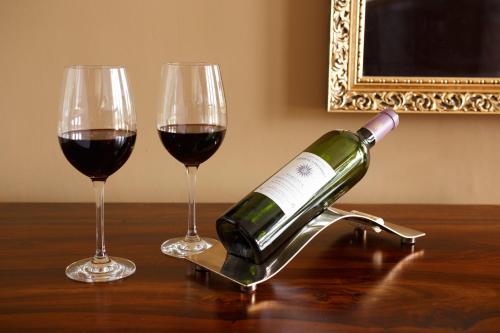 a bottle of wine sitting next to two glasses on a table at Badgers Mount Hotel in Earl Shilton
