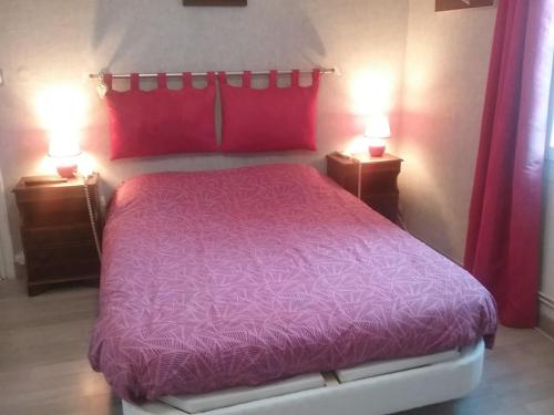 - une chambre avec un lit violet et deux lampes dans l'établissement La roseraie, à Aytré