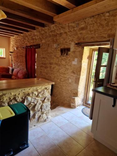 salon z kamiennym kominkiem w domu w obiekcie Gîtes Le clos de Veyrignac w mieście Veyrignac