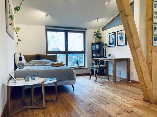 a bedroom with a bed and a table and a desk at ökologisch Wohnen im Grünen in Marburg an der Lahn